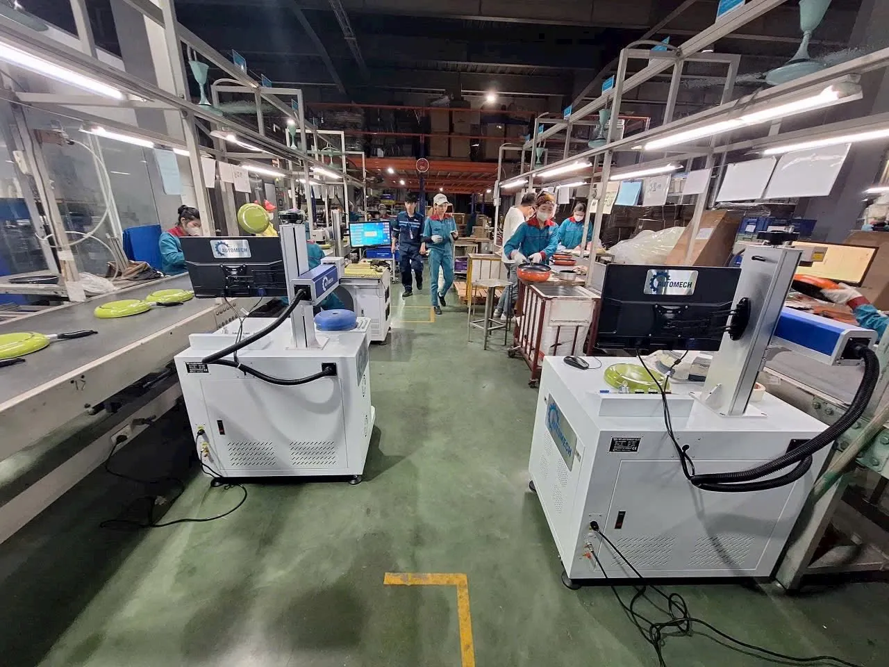 Hình ảnh thực tế các máy khắc laser Fiber cũ đang hoạt động liên tục trong dây chuyền sản xuất đồ gia dụng tại nhà xưởng.